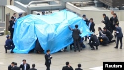 Cảnh sát và nhân viên an ninh điều tra máy bay không người lái trên nóc nhà văn phòng Thủ tướng Nhật ở Tokyo, ngày 22/4/2015.