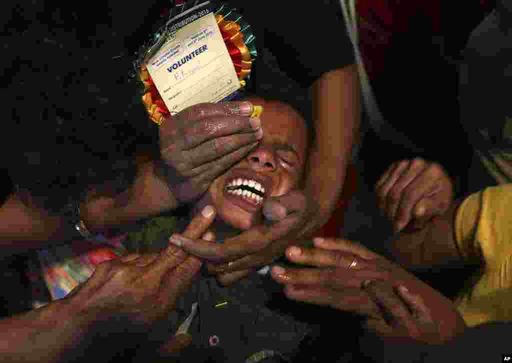 Volunteers try to open the mouth of a child suffering from asthma to administer &quot;fish medicine&quot;, in Hyderabad, India.