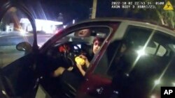 Imagen tomada del video de la cámara corporal de la policía el 2 de octubre de 2022 muestra a Erik Cantu mientras sostiene una hamburguesa en el estacionamiento de un restaurante de comida rápida en San Antonio, Texas. (Policía de San Antonio vía AP)