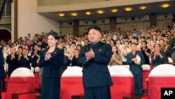 神秘女子(左)陪同金正恩等領導人看完牡丹峰樂隊表演後起立鼓掌(7月6日資料照片)
