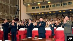 In this photo released by the Korean Central News Agency (KCNA) and distributed in Tokyo by the Korea News Service on Monday, July 9, 2012, North Korean leader Kim Jong Un, center right, and others clap as they watch performance by North Korea's new Moran