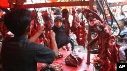 A woman buys meat at a market in Jakarta, Indonesia, Friday, Aug. 17, 2012. Today, a kilogram of beef can cost more than $13.