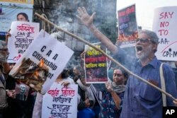 FILE—Activists and supporters of Communist Party of India (Marxist-Leninist) burn a copy of the the Citizenship Amendment Act (CAA) during a protest against CAA in Kolkata, India, March 12, 2024.