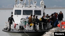 FILE - Divers return after a search and rescue operation for a South Korean ferry that sank in 2014. The South Korean Coast Guard is attempting to rescue nearly 200 people from a ferry that hit a rock off the southwest coast.