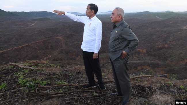 FILE - Indonesian President Joko Widodo gestures as Governor of East Kalimantan Isran Noor stands during their visit to an area, planned to be the location of Indonesia's new capital in East Kalimantan, Indonesia December 17, 2019. (Antara Foto/Akbar Nugroho Gumay/via REUTERS) 