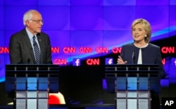 Former Secretary of State Hillary Clinton talks as Sen. Bernie Sanders of Vermont listens during the CNN Democratic presidential debate in Las Vegas, Oct. 13, 2015.