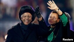 Almarhum Nelson Mandela (kiri) dan isterinya, Graca Machel melambai kepada para penonton di Soccer City pada saat penutupan Piala Dunia 2010 di Johannesburg, Afrika Selatan (foto: dok). 