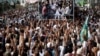 Supporters of the Tehreek-e-Labbaik Pakistan (TLP) Islamist political party raise their hands as they listen to the speech of their leader during a protest march to condemn a cartoon competition in the Netherlands, in Lahore, Pakistan, Aug. 29, 2018. 