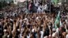 Supporters of the Tehreek-e-Labbaik Pakistan (TLP) Islamist political party raise their hands as they listen to the speech of their leader during a protest march to condemn a cartoon competition in the Netherlands, in Lahore, Pakistan, Aug. 29, 2018. 