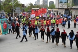 Women police officers escort activists of the Aurat March during a rally to mark International Women's Day in Islamabad on March 8, 2021.