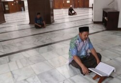 A man reads the Quran at an empty mosque in Jakarta, Indonesia, April 10, 2020.