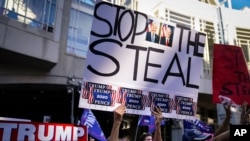 Partidarios del presidente Donald Trump se reúnen con carteles donde se lee: "Pare el robo", el alusión a supuesto fraude en conteo de votos, en el Centro de Convenciones de Filadelfia, el viernes 6 de noviembre de 2020..
