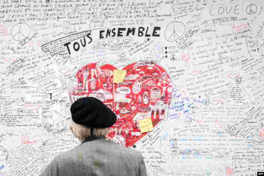 A man looks at a memorial panel for the victims of the March 22 attacks at the entrance of the Maelbeek-Maalbeek subway station in Brussels, Belgium.