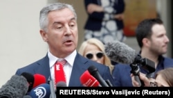 Arhiva - Milo Đukanović, predsednički kandidat DPS-a, razgovara sa novinarima ispred biračkog mesta na dan održavanja izbora za predsednika Crne Gore, u Podgorici, 15. aprila 2018.