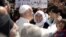 FILE - Pope Francis greets migrants and refugees at Moria refugee camp near the port of Mytilene, on the Greek island of Lesbos, April 16, 2016. 