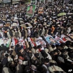 Anti-government protestors pray around the bodies of the demonstrators who were killed on Friday's clashes with Yemeni security forces, during their funeral procession in Sanaa,Yemen, March 20, 2011