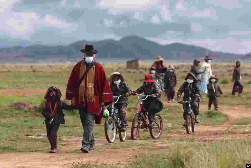 Aymaran Indigenous parents walk their children to Jancohaqui Tana school as they return for their first week of in-person classes amid the COVID-19 pandemic, near Jesus de Machaca, Bolivia.