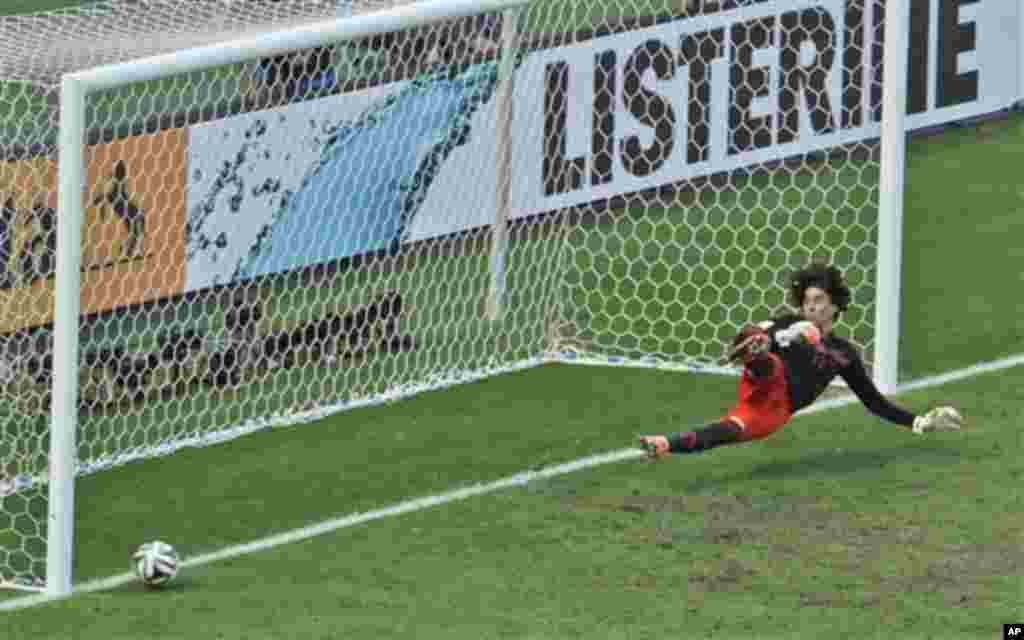 Mexico's goalkeeper Guillermo Ochoa fails to save a shot by Netherlands' Klaas-Jan Huntelaar from the penalty spot during the World Cup round of 16 soccer match between the Netherlands and Mexico at the Arena Castelao in Fortaleza, Brazil, Sunday, June 29