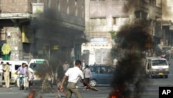 An anti-government protester burns tires during a protest to demand the ouster of Yemen's President Ali Abdullah Saleh in the southern city of Taiz, May 10, 2011
