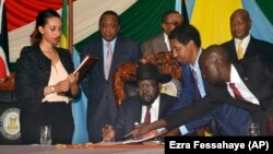 Presiden Sudan Selatan Salva Kiir (duduk bertopi) saat menandatangani kesepakatan perdamaian dengan pemberontak di Juba, Rabu (26/8).