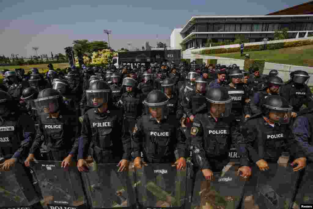 Riot police officers stand guard at the gate of the Army Club where Prime Minister Yingluck Shinawatra was holding a meeting in Bangkok, Jan. 28, 2014.