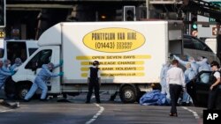 Forensic officers move the van at Finsbury Park in north London, where a vehicle struck pedestrians in north London, June 19, 2017.
