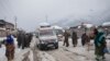 An ambulance ferries patients to a hospital through a snow-covered road in Kangan, north of Srinagar, India-controlled Kashmir, Jan. 14, 2020.
