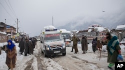 An ambulance ferries patients to a hospital through a snow-covered road in Kangan, north of Srinagar, India-controlled Kashmir, Jan. 14, 2020.