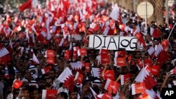 Tens of thousands of Bahrainis wave flags and carry a mock casket representing a recent dialogue rejected by many government opponents during a protest march in Saar, July 29, 2011