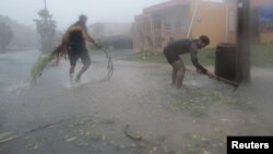 Des habitants débarassent la rue de débris après le passage de l'ouragan Irma à Puerto Rico le 6 septembre 2017. 