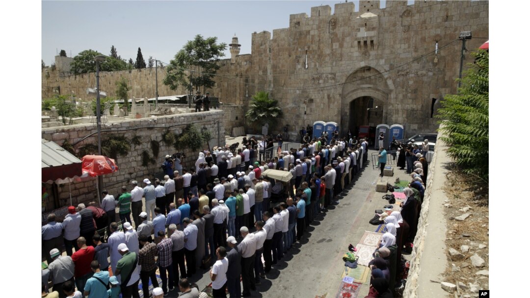 Palestinians pray outside the Lion's Gate in Jerusalem's Old City, July 18, 2017. A dispute over metal detectors has escalated into a new showdown between Israel and the Muslim world over a contested Jerusalem shrine.