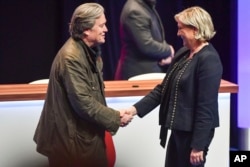 FILE - National Front party leader Marine Le Pen (R) greets on stage former White House strategist Steve Bannon at the party congress in the northern French city of Lille, March 10, 2018.