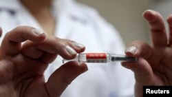 Seorang perawat menunjukkan satu dosis vaksin Covid-19, CoronaVac, buatan Sinovac dari China, sebelum menyuntikkan ke relawan di Emilio Ribas Institute di Sao Paulo, Brazil, 30 Juli 2020. 