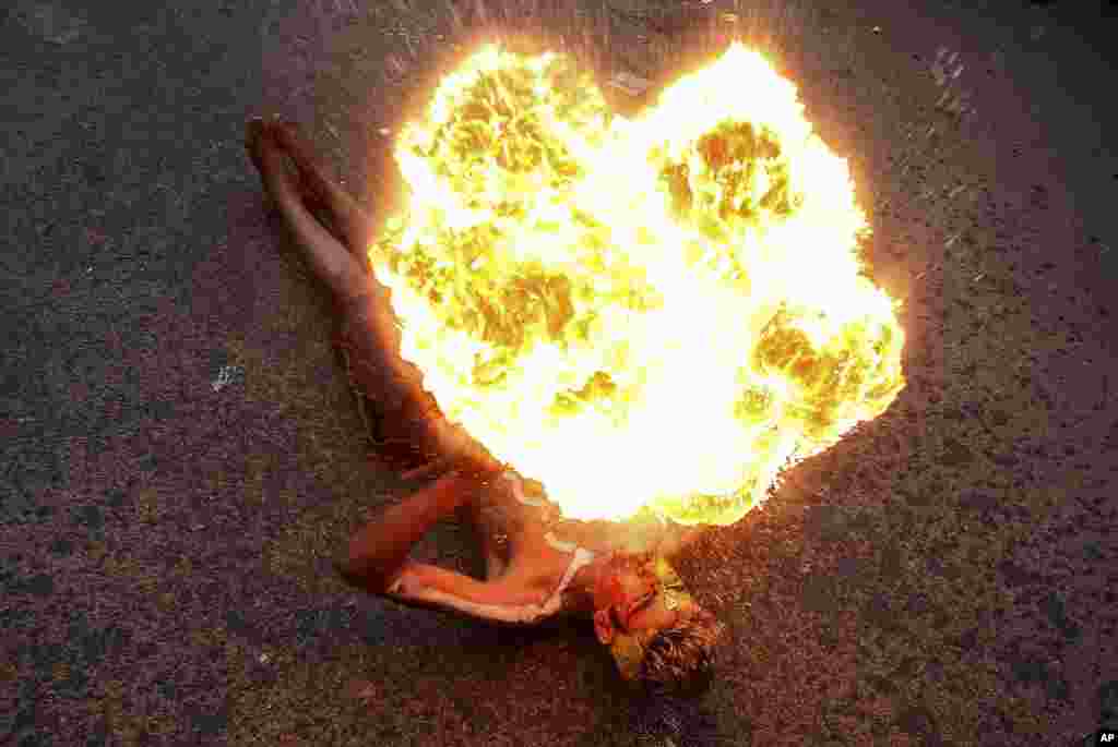 An artist performs with fire during a procession as part of "Bonalu" festival in Hyderabad, India.