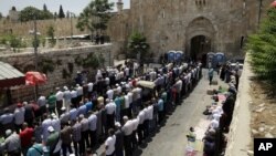 Warga Palestina melakukan sholat jamaah di luar pintu 'Gerbang Domba' di kota tua Yerusalem (18/7). 