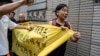 FILE - Members of League of Social Democrats hold banner outside the West Kowloon Magistrates' Courts in Hong Kong, May 30, 2024, ahead of verdicts in national security case. The banner reads "Exercising Constitutional rights is not a crime."