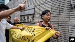 FILE - Members of League of Social Democrats hold banner outside the West Kowloon Magistrates' Courts in Hong Kong, May 30, 2024, ahead of verdicts in national security case. The banner reads "Exercising Constitutional rights is not a crime."