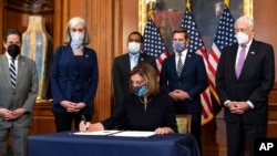 House Speaker Nancy Pelosi of California signs the article of impeachment against President Donald Trump in an engrossment ceremony before transmission to the Senate for trial on Capitol Hill, in Washington, Jan. 13, 2021. 