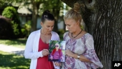 Angela Ermold, right, and her sister, Denise Gracely, hold a photo of their mother, Marian Rauenzahn, Thursday, June 17, 2021, in Fleetwood, Pa. (AP Photo/Matt Slocum)