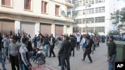 Algerian youth protesters clash with riot police in Annaba, Algeria. Many held signs reading "Bouteflika out," in reference to President Abdelaziz Bouteflika, in power since 1999, February 13, 2011