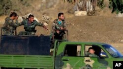 FILE - Syrian soldiers arrive to Syria's Quneitra border crossing between Syria and the Israeli-controlled Golan Heights, July 26, 2018. Russian President Vladimir Putin's envoy to Syria says Iran-backed fighters have withdrawn more than 80 kilometers (50 miles) from Syria's frontier with the Israeli-occupied Golan Heights in order not to "irritate" Israel. Alexander Lavrentyev told the Russian Interfax news agency on Wednesday, Aug. 1, that an agreement was reached "with Russian guarantees," without elaborating. 