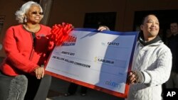 Thuy Nguyen, derecha, acepta un millón de dólares de comisión por haber vendido el número ganador de la Mega Millions en California.