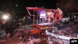 
Des personnes sont rassemblées après une frappe aérienne sur un marché dans la ville de Maarat al-Numan, en Syrie, le 21 mai 2019.
