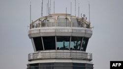 A man gestures inside the control tower of Reagan National Airport after an American Airlines flight crashed into the river after colliding with a US Army helicopter, near Washington, DC, on January 30, 2025.