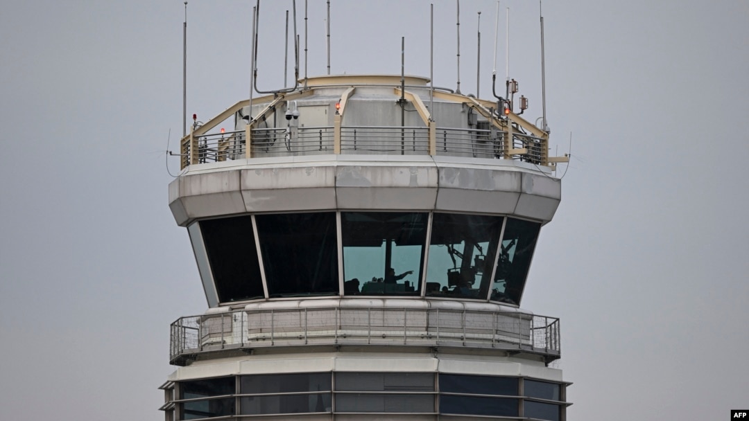 A man gestures inside the control tower of Reagan National Airport after an American Airlines flight crashed into the river after colliding with a U.S. Army helicopter, near Washington, D.C., Jan. 30, 2025.