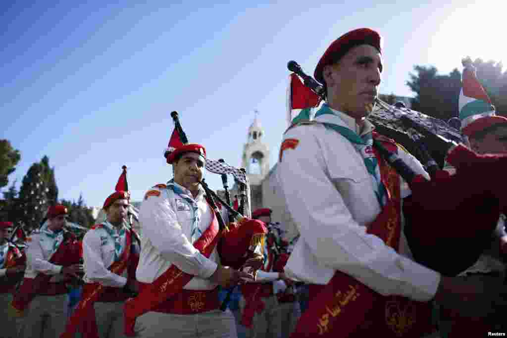 Anggota pramuka Palestina berpartisipasi dalam parade prosesi Natal di Alun-Alun Manger, di depan Gereja Nativity tempat kelahiran Yesus (24/12).