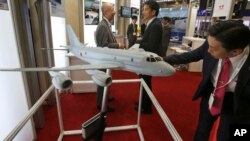 A visitor looks at a miniature model of P-1 Maritime Patrol Aircraft of Kawasaki Heavy Industries, during " MAST Asia", Japan's international arms exhibit, in Chiba, near Tokyo, June 12, 2017.