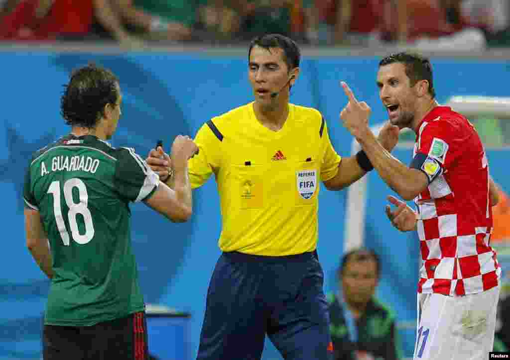ریفری ایماٹوو میکسیکو کے کھلاڑی گوارڈاڈو اور کروئشیا کےاسما کے درمیان ہونے والی بحث کو روک روہے ہیں