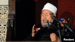 ທ່ານ Sheikh Yusuf al-Qaradawi ຊາວອີຈິບທີ່ນັກບວດມຸສລິ​ມນິກາຍ Sunni, ປະທານຂອງສະຫະພາບນັກປັນຍາຊົນມຸສລິມສາກົນ ກ່າວຄໍາປາໄສ ໃນໄລຍະ ທີ່ມີການໄຫວ້ພະໃນວັນສຸກ ກ່ອນຈະມີການປະທ້ວງຕໍ່ຕ້ານ ປະທານາທິບໍດີ Assad ທີ່ວັດອິສລາມແຫ່ງນຶ່ງ ໃນກຸງໄຄໂຣຂອງອີ່ຈິບ ໃນວັນທີ 28 ທັນວາ 2012.