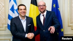 PM Yunani Alexis Tsipras (kiri) bersalaman dengan PM Belgia Charles Michel sebelum pertemuan di Brussels, Kamis (12/2). 